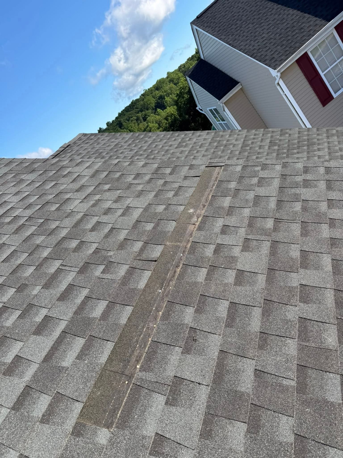 Section of shingle roof missing shingles, needing repair